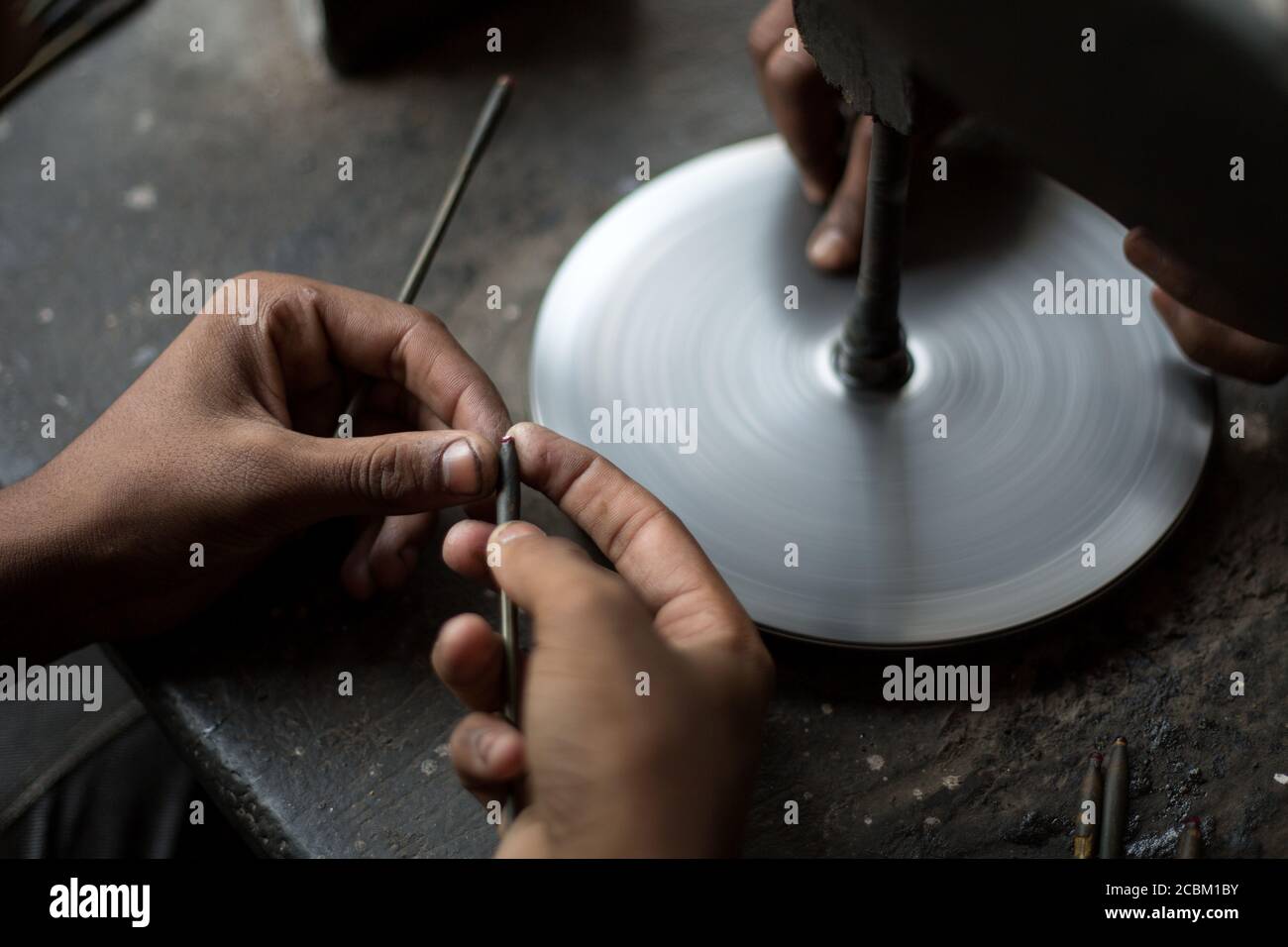 Primo piano di mani che lucidano i rubini in officina, Jaipur, Rajasthan, India Foto Stock