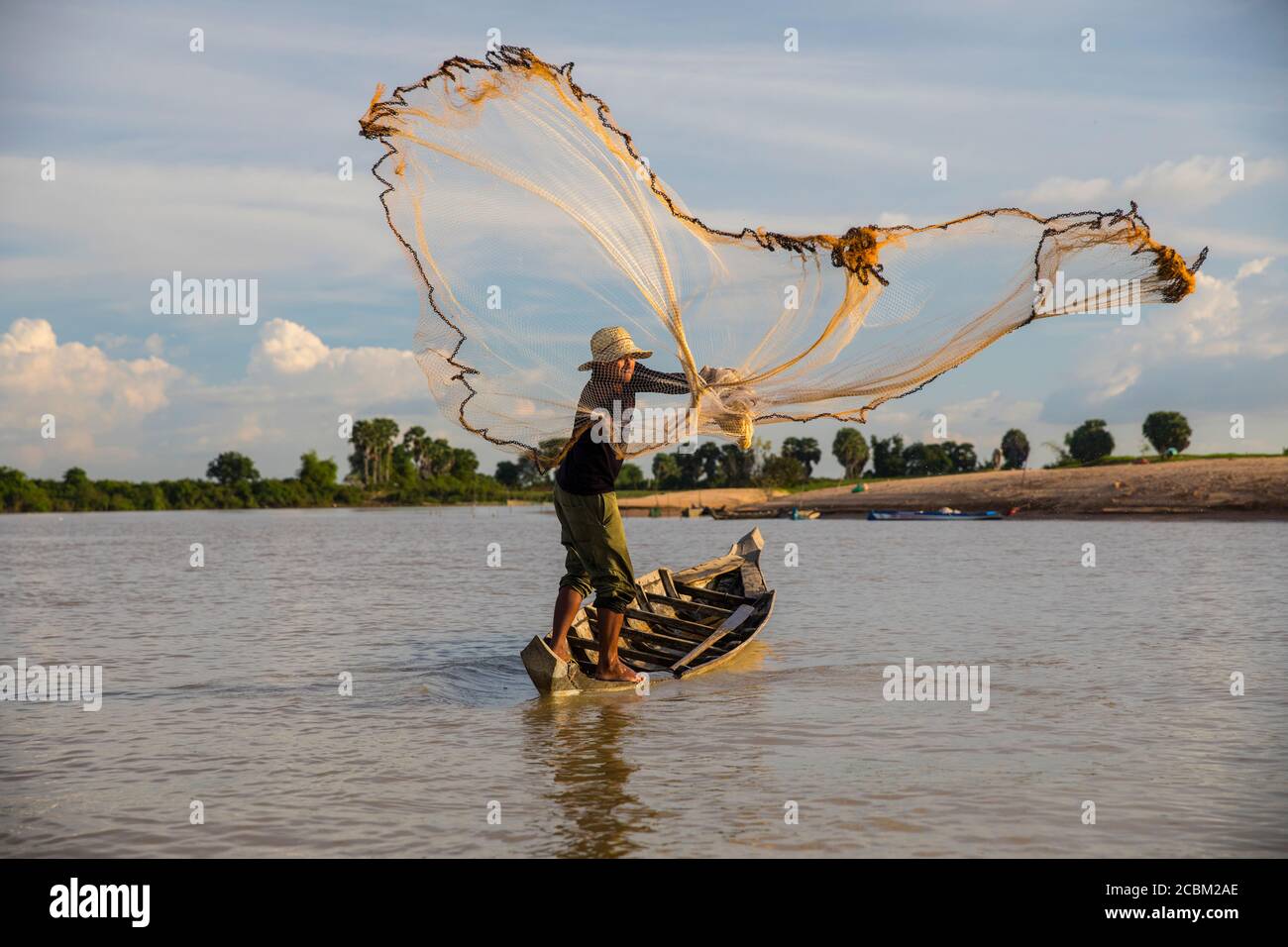 Pescatore locale gettando rete sul fiume Steung Saen, Kampong Thum, Cambogia Foto Stock