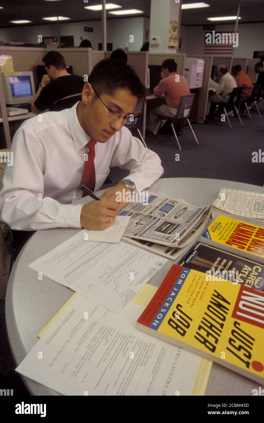 Austin, Texas USA, 1998: Maschio ispanico, 23, cerca la posizione clericale di entrata-livello usando le risorse della biblioteca pubblica e il giornale locale. Versione del modello. ©Bob Daemmrich Foto Stock