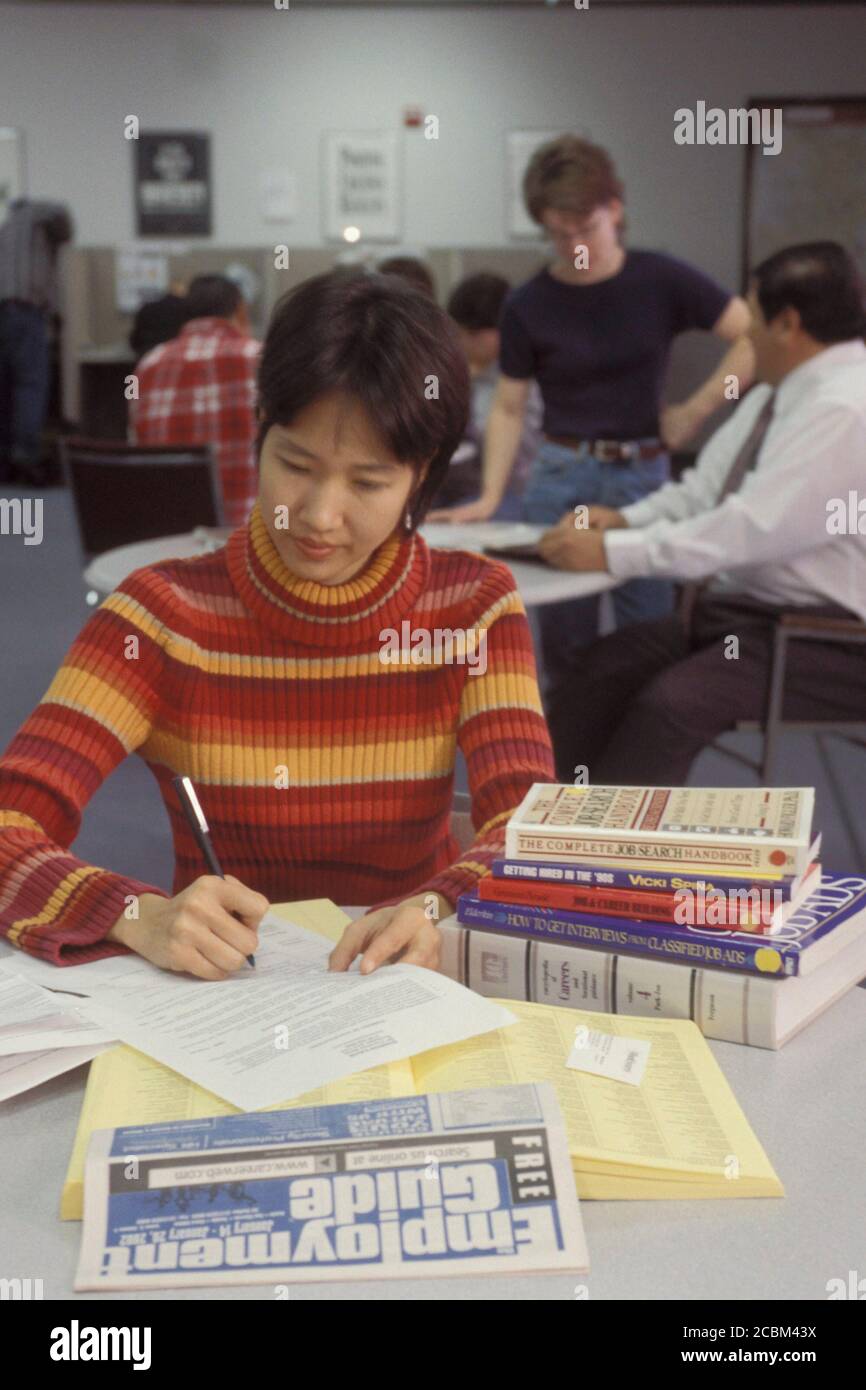 Austin, Texas USA, 1998: Asian-American femmina, 23, cerca la posizione di base usando le risorse del centro di occupazione dello stato del Texas e il giornale locale. Versione del modello. ©Bob Daemmrich Foto Stock