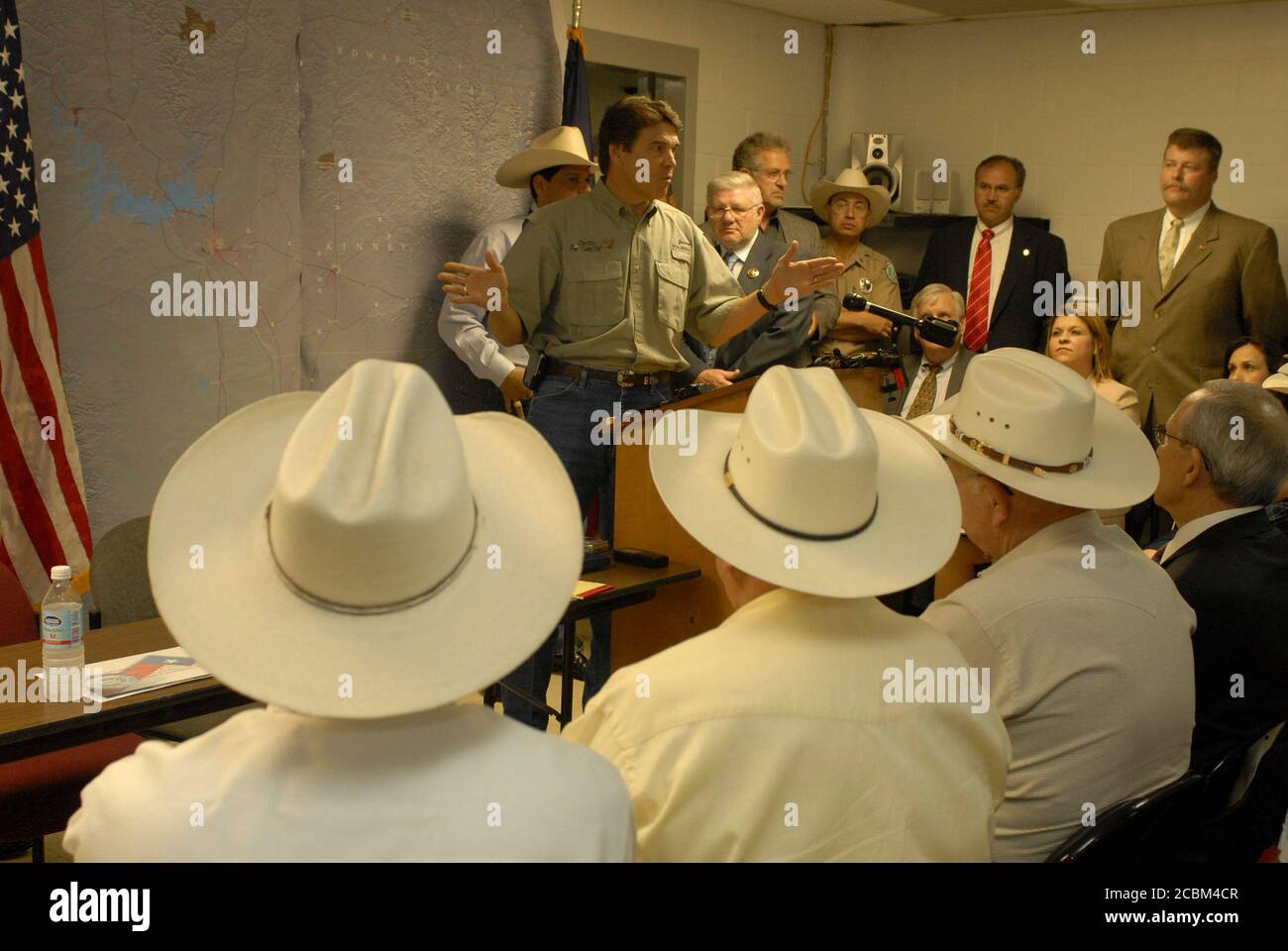 Del Rio, Texas USA, 27 giugno 2006: Il governatore del Texas Rick Perry  parla con i funzionari delle forze dell'ordine, inclusi gli sceriffi delle  contee di confine del Texas (in cappelli), in