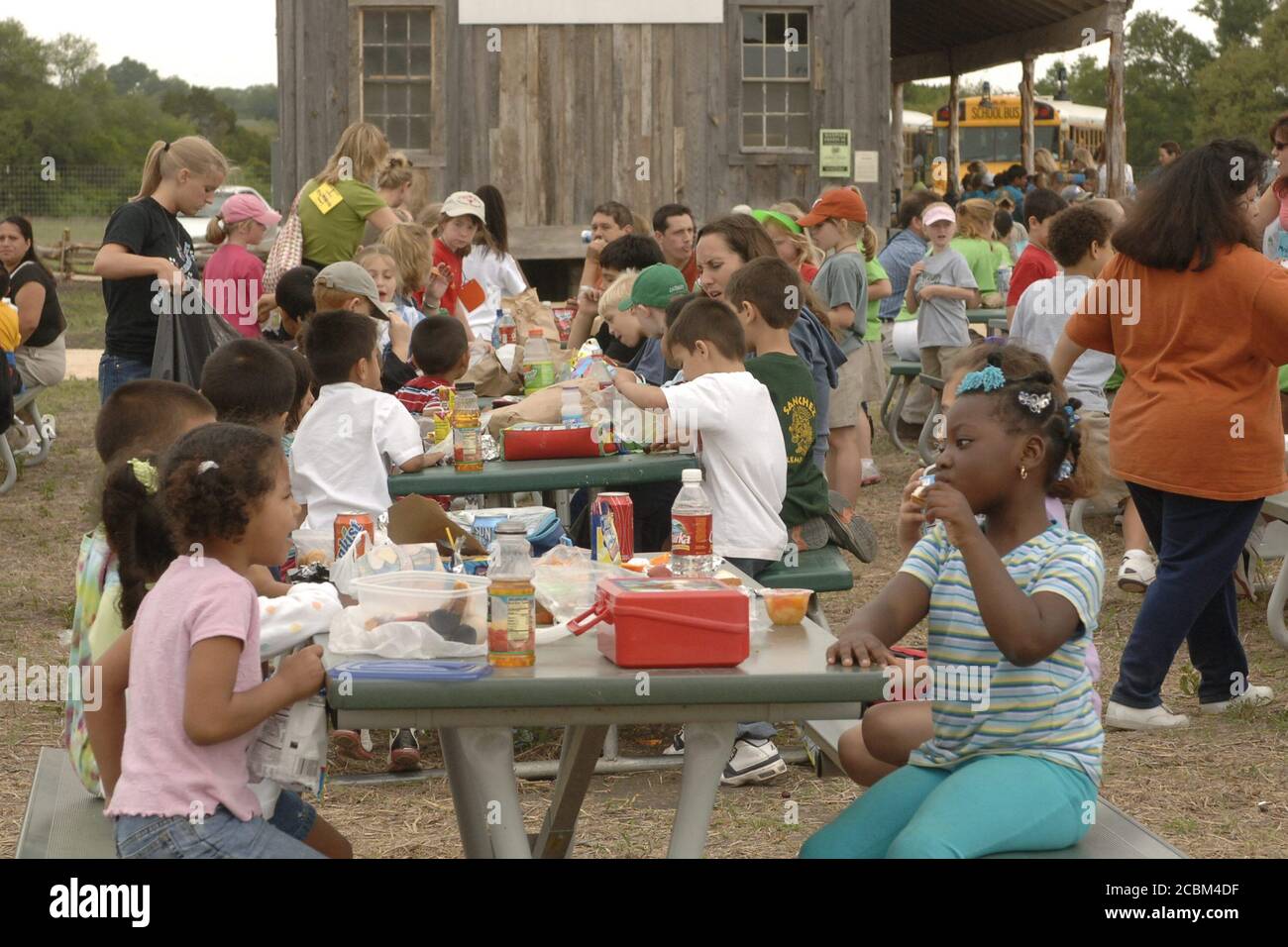 Austin, Texas USA, maggio 2006: Gli studenti elementari mangiano il pranzo durante la gita scolastica in un'azienda agricola restaurata del XIX secolo. ©Bob Daemmrich Foto Stock