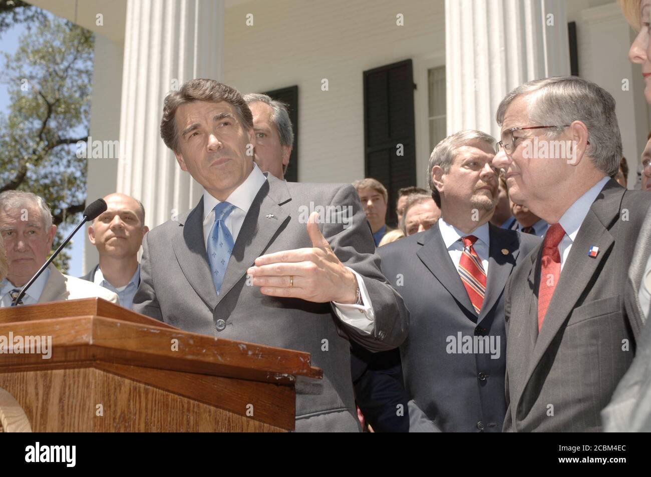 Austin, Texas 17 maggio 2006: Il governatore del Texas Rick Perry (a podio) discute la nuova tassa sulle imprese promulgata in una sessione speciale fuori dalla residenza del Governatore con i leader aziendali di stato in presenza. All'estrema destra (in occhiali) è il relatore della Casa Tom CRaddick. ©Bob Daemmrich Foto Stock