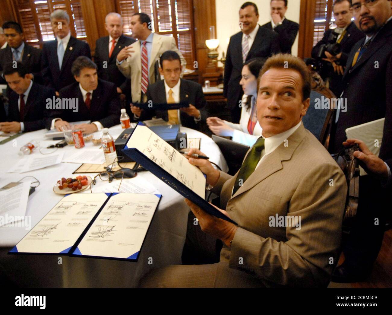 Austin, Texas USA, 25 agosto 2006: California Gov. Arnold Schwarzenegger firma la Dichiarazione congiunta alla sessione di lavoro della Conferenza dei Governatori di frontiera, in cui quattro governatori statunitensi e sei messicani si sono incontrati per discutere questioni di reciproca preoccupazione lungo il confine tra Stati Uniti e Messico. ©Bob Daemmrich Foto Stock