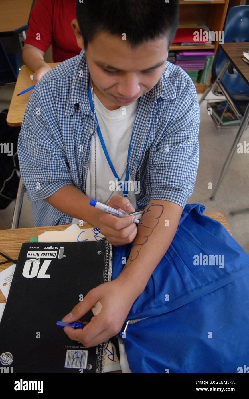 Austin, TX 22 settembre 2006: Lo studente maschile usa un marcatore Sharpie per scrivere sul braccio i durante la classe alla Travis High School, una scuola prevalentemente ispanica sul lato sud di Austin. ©Bob Daemmrich Foto Stock