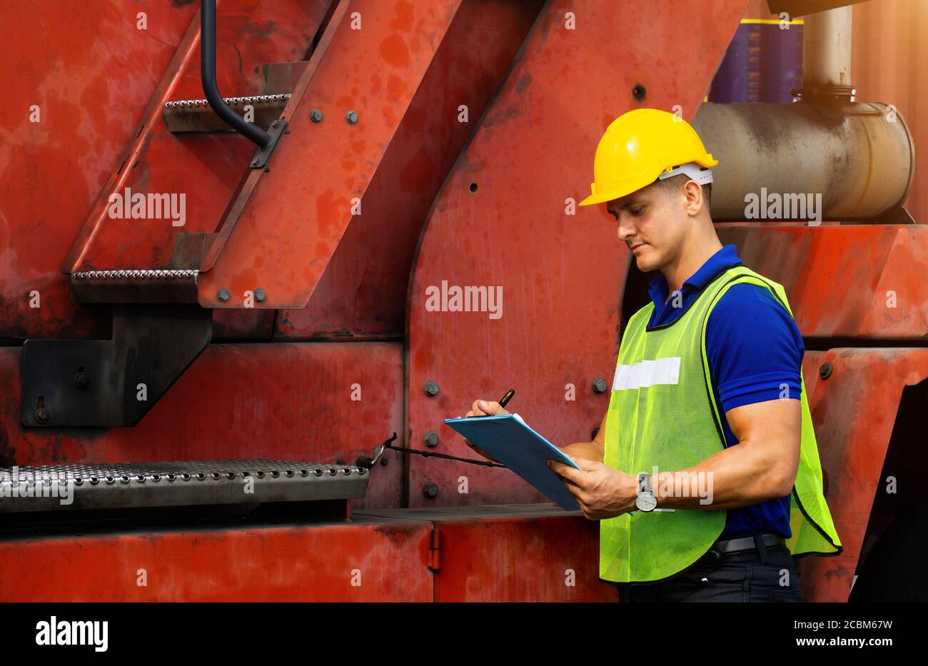 Uomini lavoratori industriali o ingegneri che controllano il processo delle macchine nel settore della logistica. Foto Stock