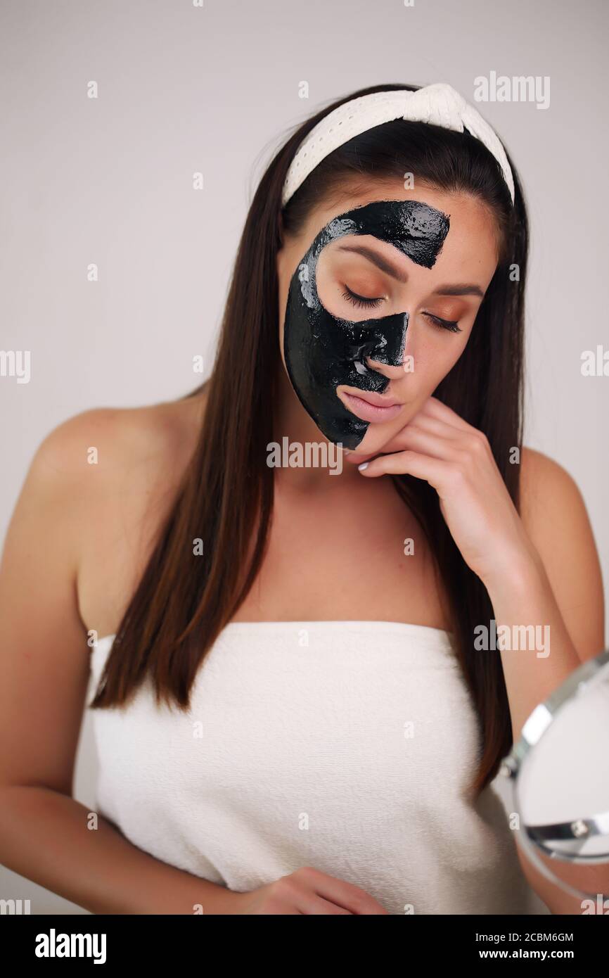 Giovane e bella donna con maschera nera a strappo sul viso dopo la doccia  Foto stock - Alamy