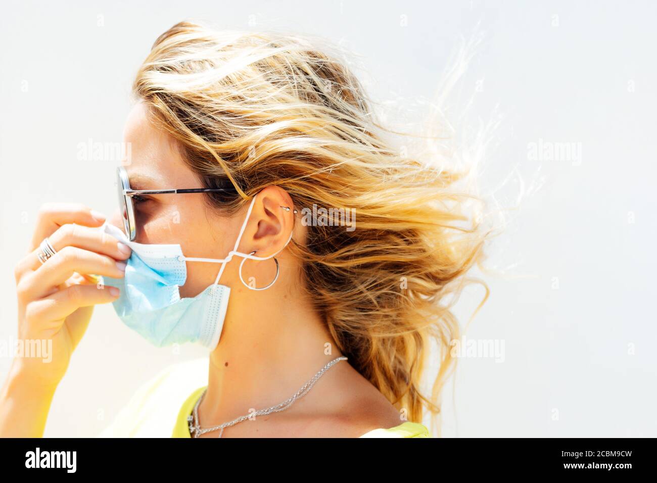 Donna che mette sulla maschera. Sulla strada. Foto Stock