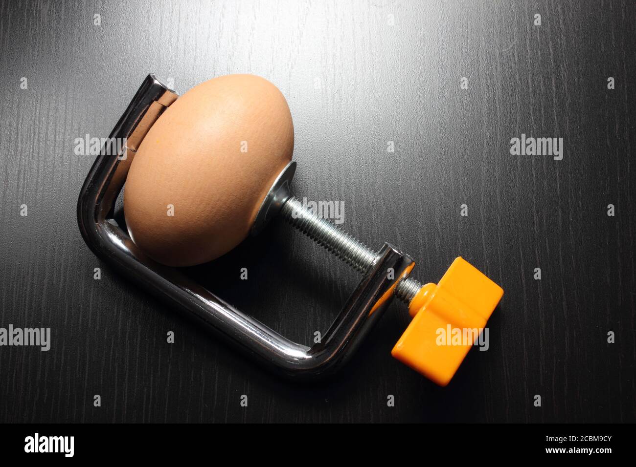 Uovo con morsetto su sfondo di legno Foto Stock