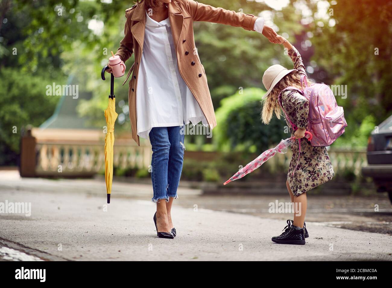 Mamma e figlia camminano insieme alla scuola Foto Stock