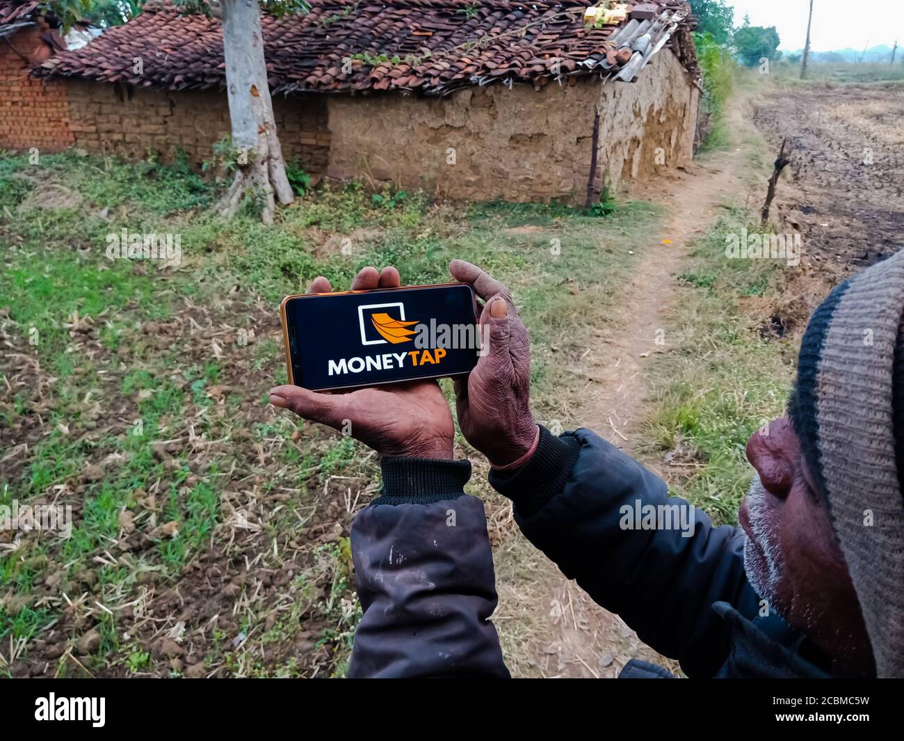 DISTRETTO KATNI, INDIA - 20 DICEMBRE 2019: Soldi Tap Instant Loan portale online presentato su smart phone schermo digitale da parte della mano di gente del villaggio indiano Foto Stock
