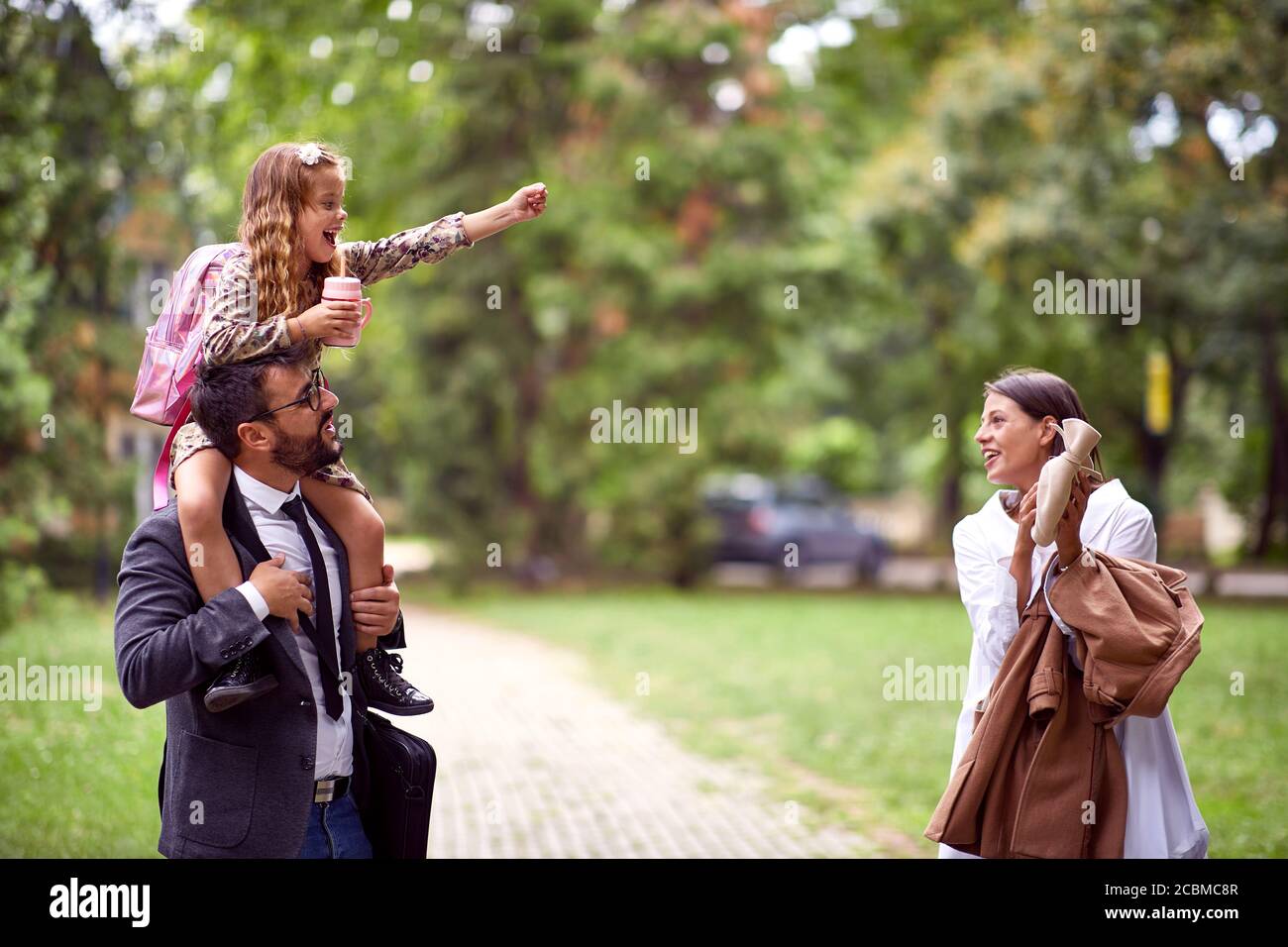 Madre e padre giocano con la figlia dopo la scuola Foto Stock