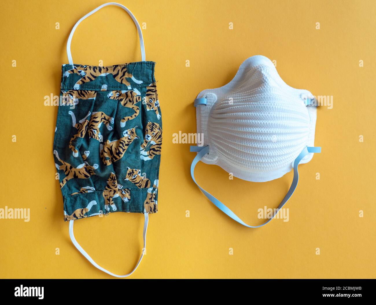 Confronto di due diverse maschere facciali, una maschera in cotone e una maschera medica N95 per la protezione contro il virus Corona Foto Stock