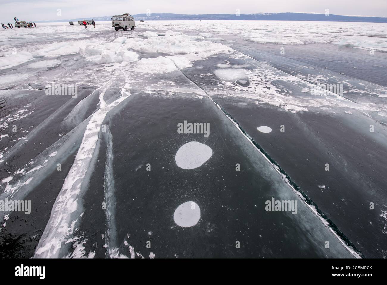 Crepe di ghiaccio e bolle di metano sulla superficie congelata del lago Baikal, Russia Foto Stock