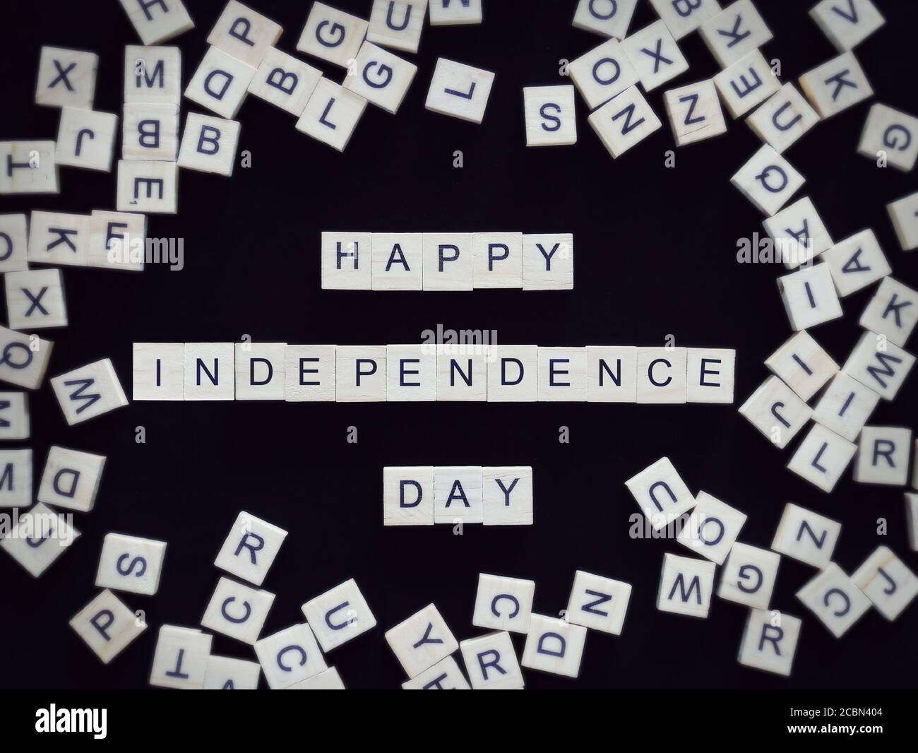 Happy Independence Day biglietto di auguri, lettere alfabetiche parola felice indipendenza giorno su pezzi di legno, isolato su nero per sfondo Foto Stock