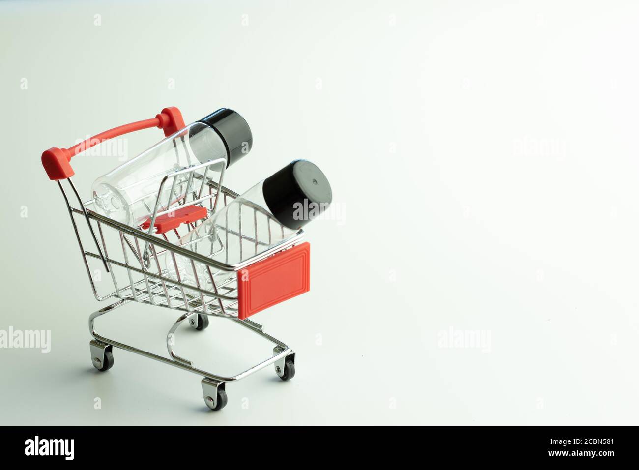 Carrello con bottiglie vuote per cosmetici, concetto di vendita moda. Concetto di distribuzione online. Sfondo bianco con spazio per la copia Foto Stock