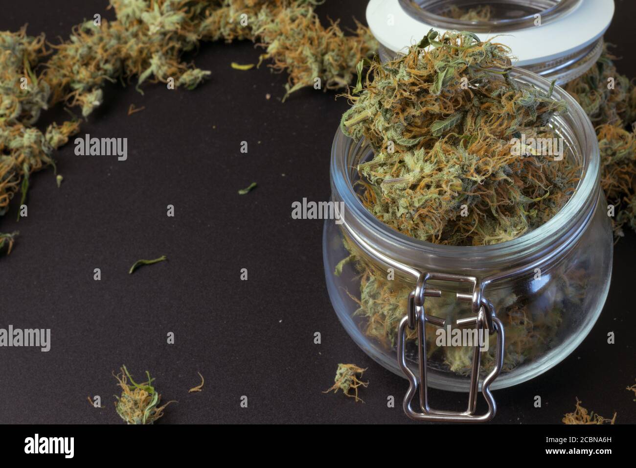 Giara di cannabis medica con copia di sfondo con marijuana. THC uso legale di droga nel settore sanitario. Industria delle erbacce Foto Stock
