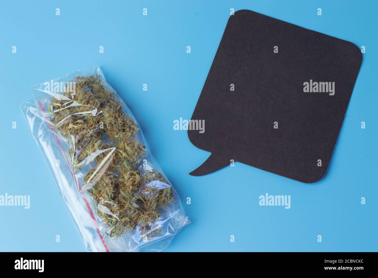 Pacchetto di cannabis e bolla di dialogo con spazio di copia vista dall'alto deisgn. Foto Stock