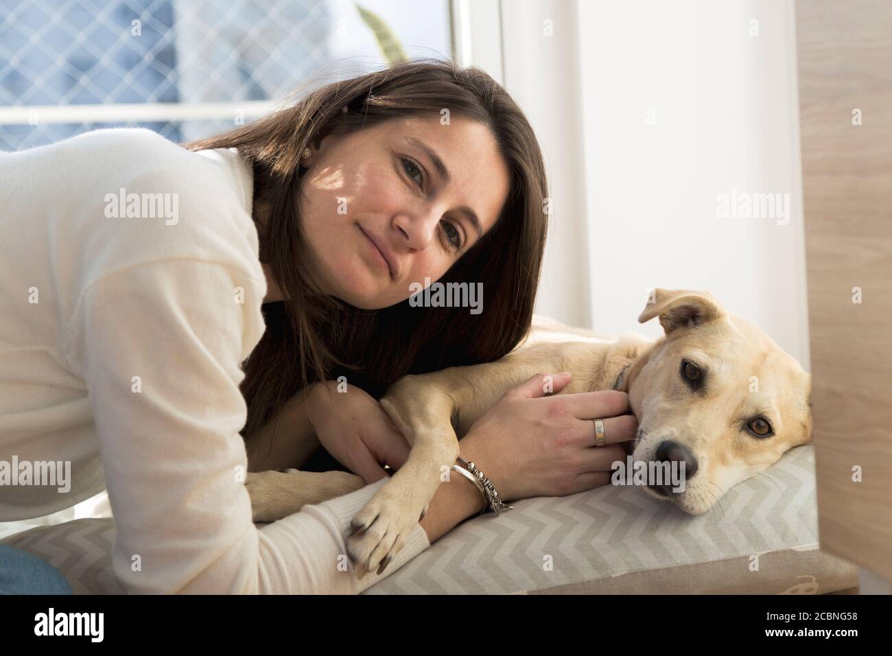 Ritratto di una giovane donna con un cane. Ragazza in casa con il suo cane. Foto Stock