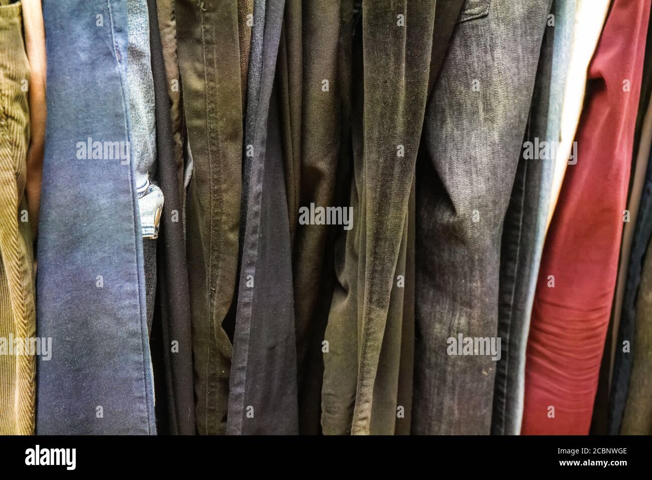 Primo piano di vecchi jeans e pantaloni esposti al negozio Thrift Foto Stock