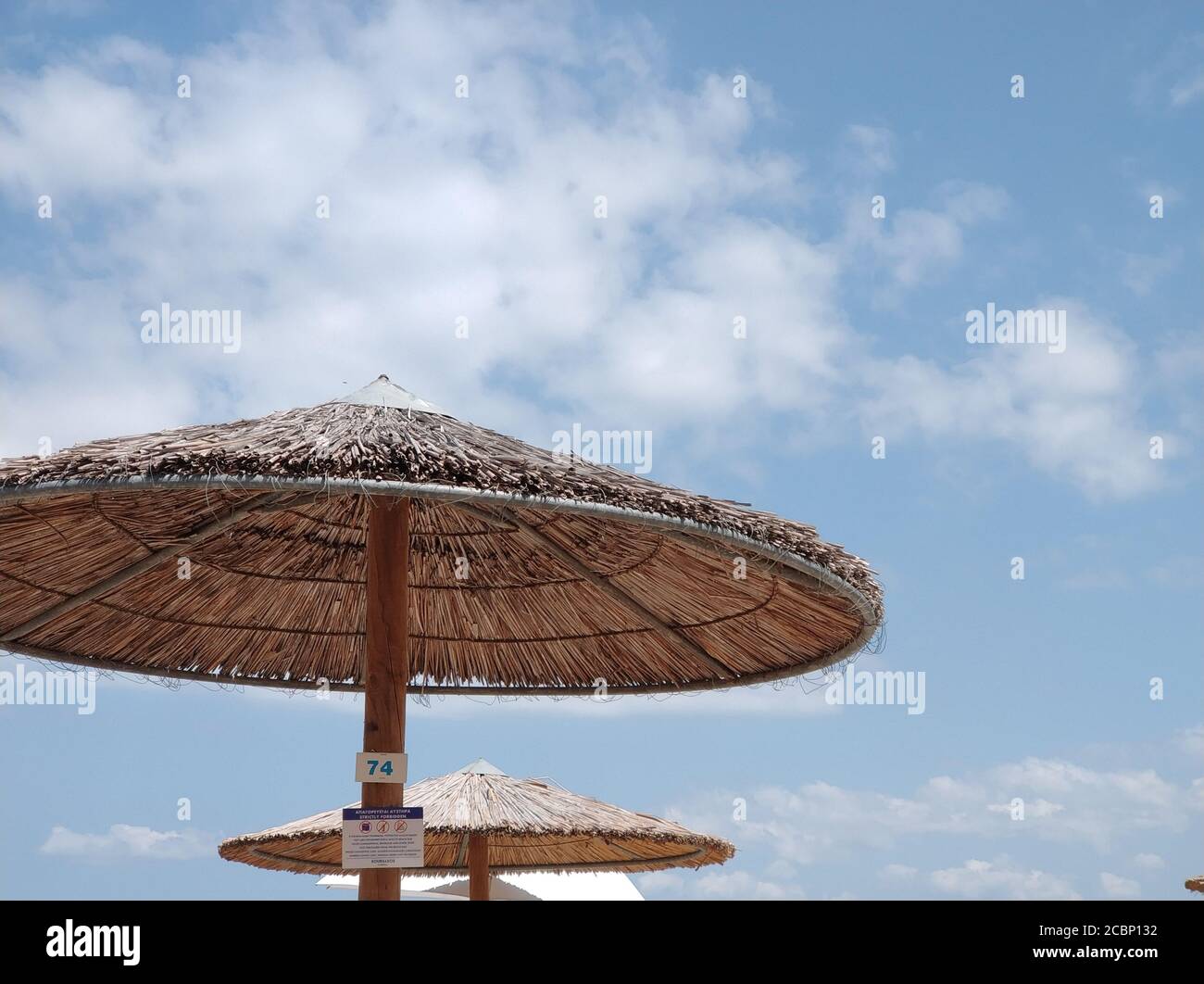 A basso angolo di ombrelli di paglia sulla spiaggia a. giorno Foto stock -  Alamy