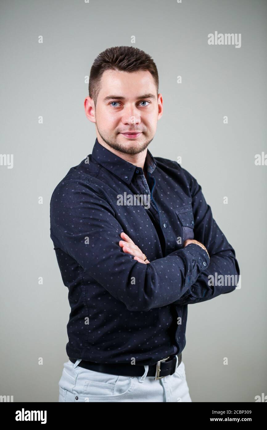 Giovane uomo d'affari in camicia nera e pantaloni bianchi su uno sfondo  bianco Foto stock - Alamy