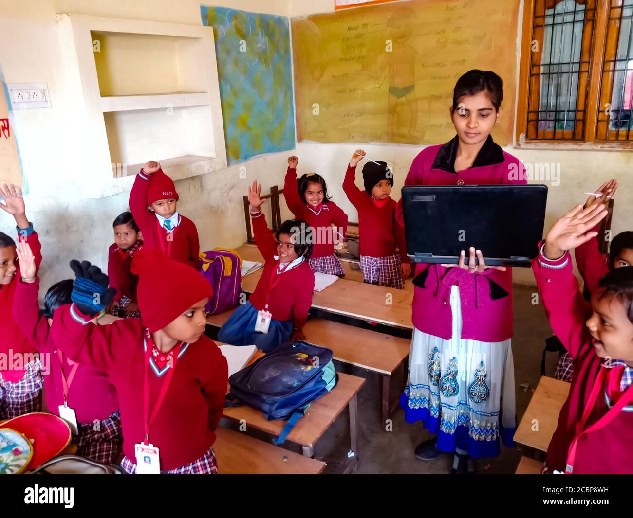 DISTRETTO KATNI, INDIA - 13 GENNAIO 2020: Insegnante di computer femminile della scuola primaria indiana che fornisce la formazione circa la tecnologia di laptop agli studenti a. Foto Stock