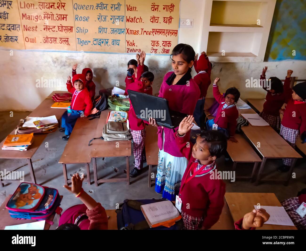 DISTRETTO KATNI, INDIA - 13 GENNAIO 2020: Insegnante della signora della scuola primaria indiana che dà formazione circa la tecnologia del laptop agli allievi alla stanza della classe. Foto Stock