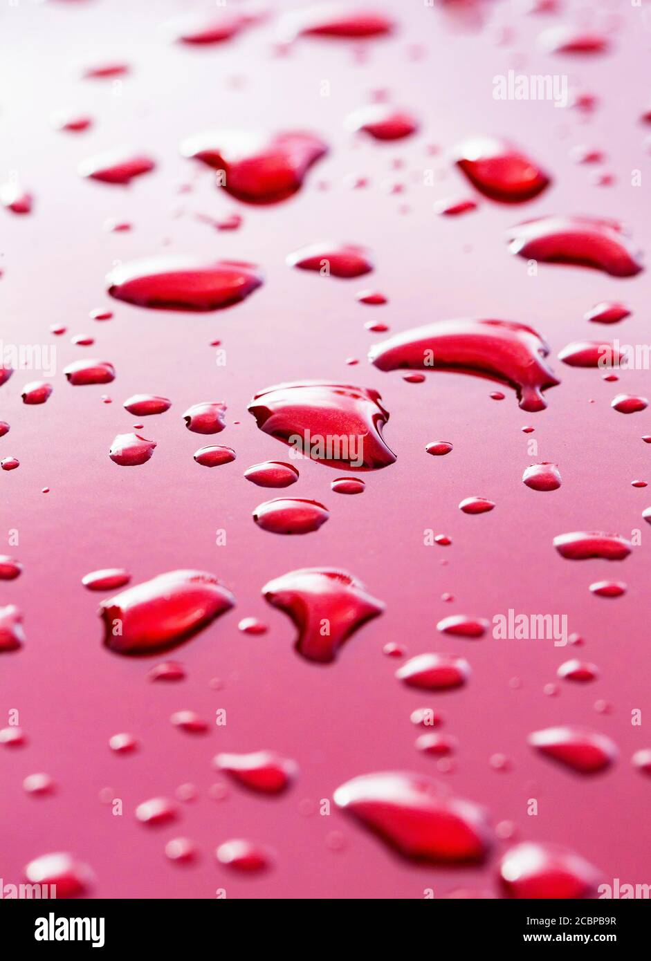 Gocce di pioggia su vernice rossa dell'automobile, Austria Foto Stock
