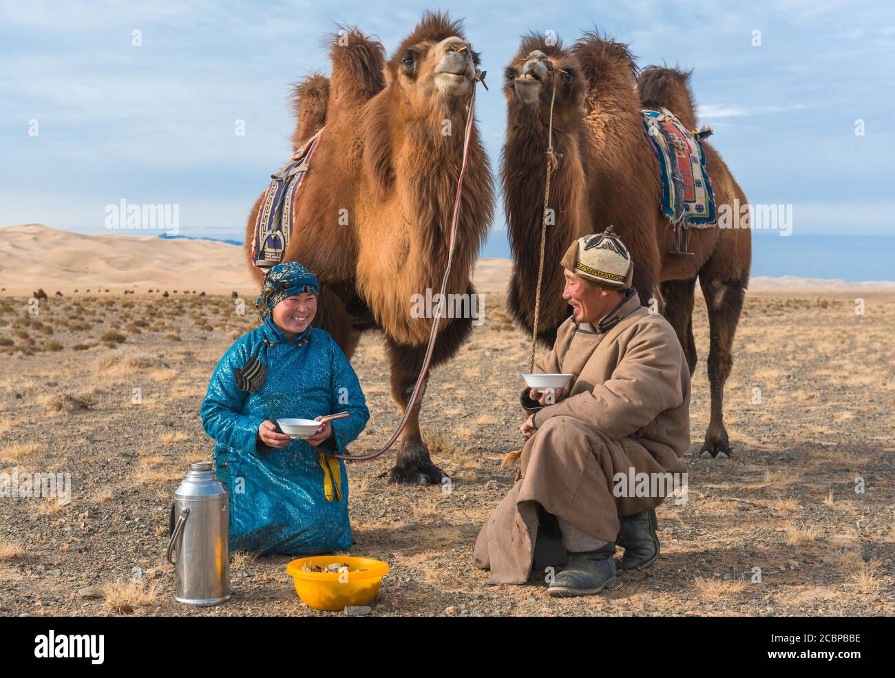 Pastori con i loro cammelli a pranzo, Umnugovi aimag, Mongolia Foto Stock