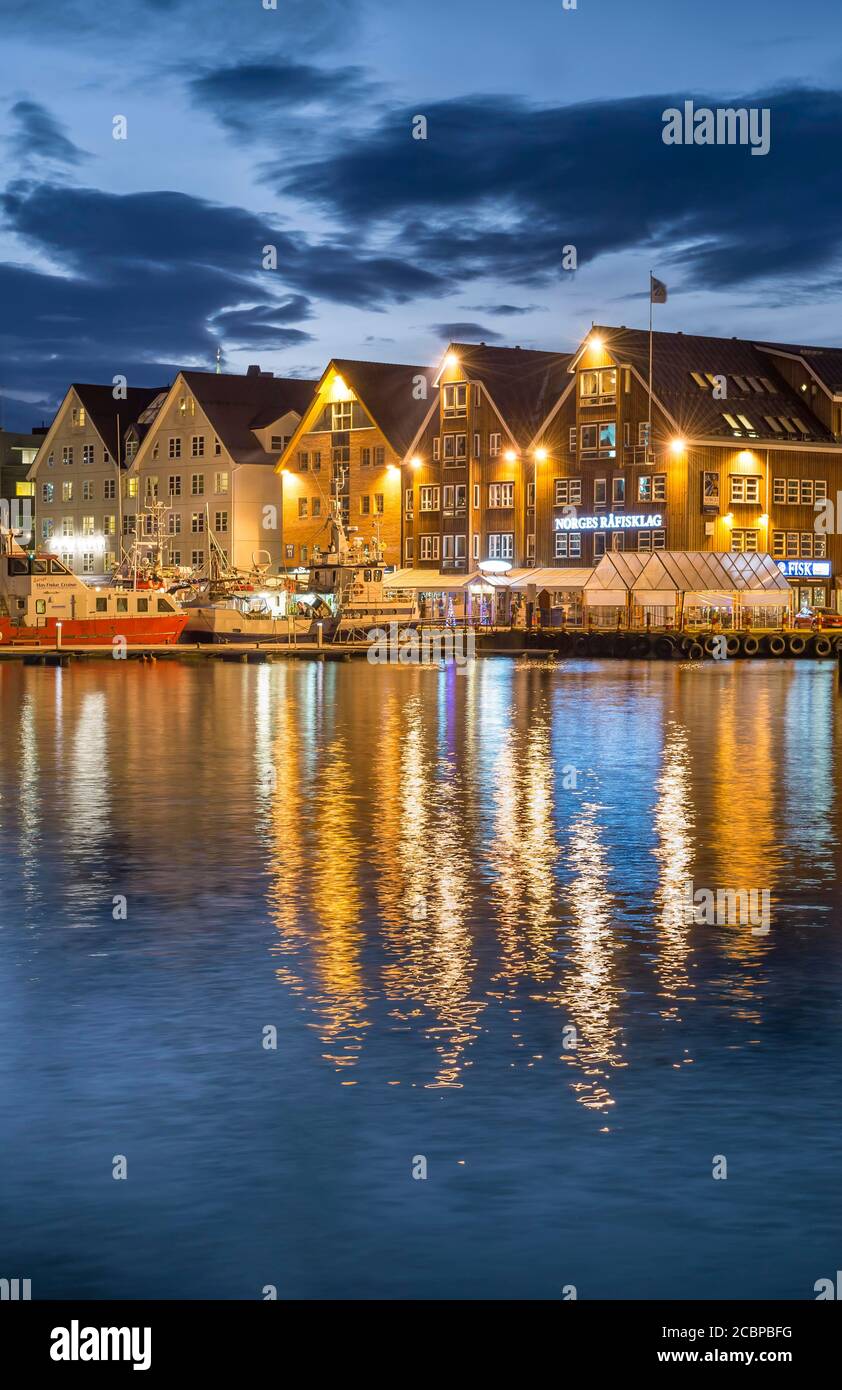 Fila illuminata di case al porto con riflessione in mare, notte polare, Tromsoe, Troms, Norvegia Foto Stock