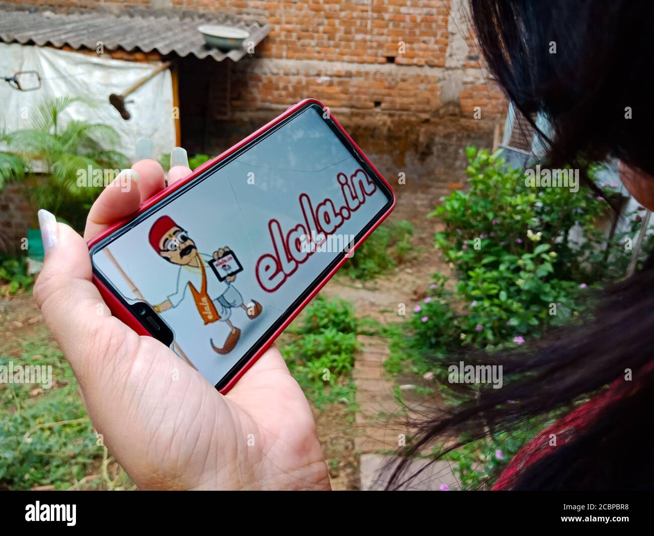 DISTRETTO KATNI, INDIA - 27 APRILE 2020: Una ragazza indiana ha presentato il logo cartoon e-lala sullo schermo del telefono intelligente, per il concetto di consapevolezza di apprendimento e-commerce. Foto Stock