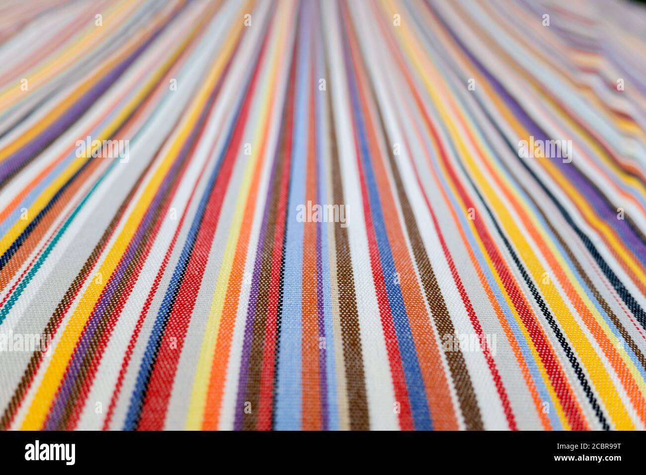 Linee colorate parallele su un tessuto, sfondo sfocato fuori fuoco alla fine Foto Stock