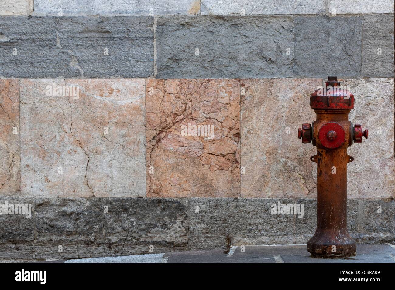 idrante rosso con fondo in pietra Foto Stock