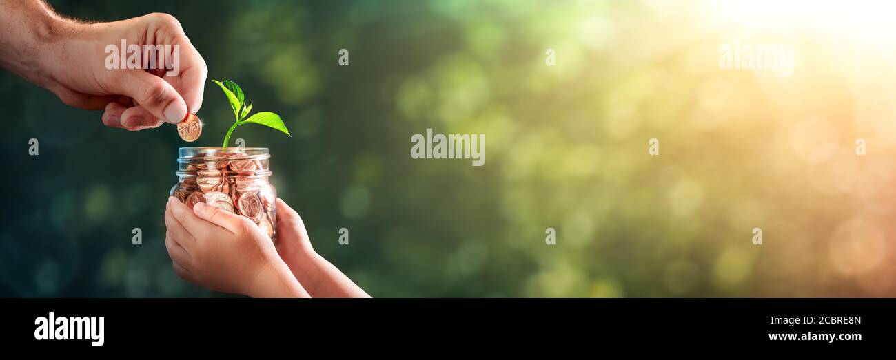 Mano di Padre che aggiunge Penny al vasetto di moneta del bambino con Pianta che cresce fuori di esso - Fondo del Collegio / investimento Nel concetto futuro dei nostri bambini Foto Stock