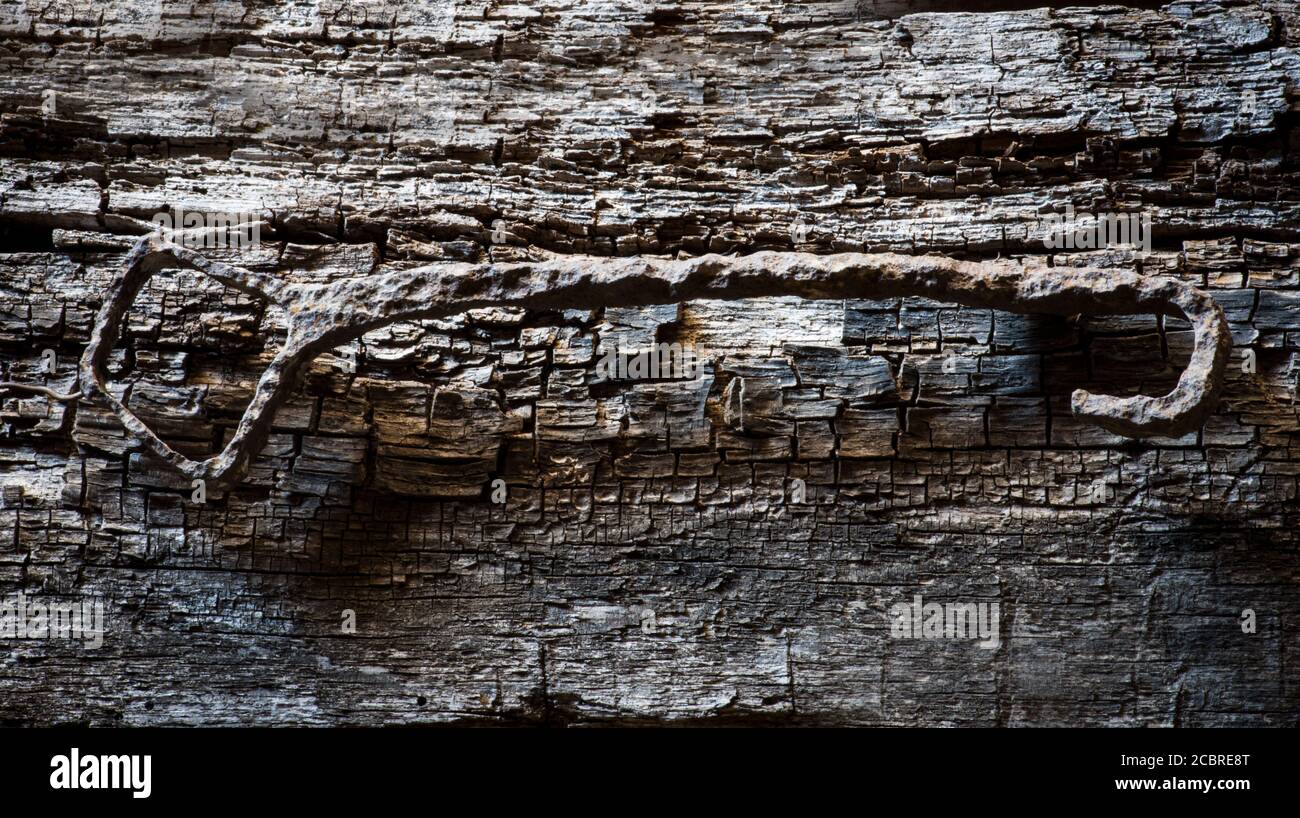 Antica chiave di ferro arrugginita, su vecchio sfondo di legno di quercia Foto Stock