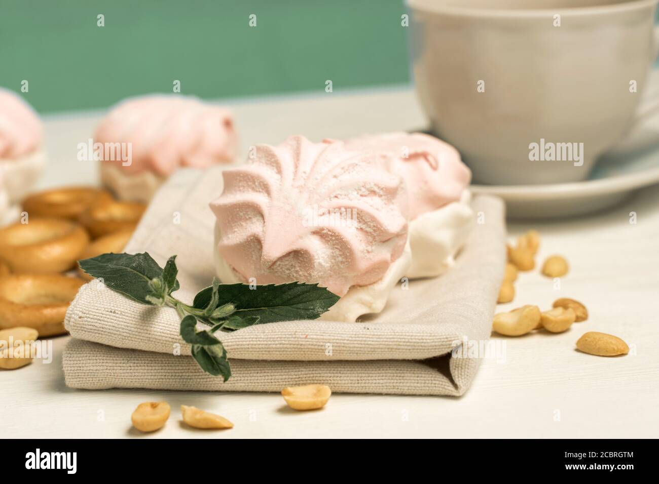 dolci e una tazza di tè. marshmallow, bagel e noci con foglia di menta Foto Stock