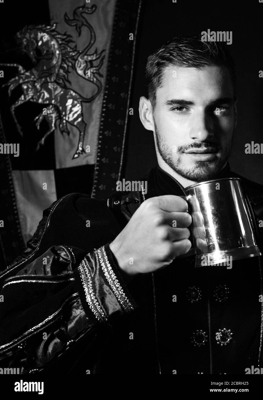 Ritratto di re attraente con barba vestita in costume con tankard guardando la macchina fotografica Foto Stock