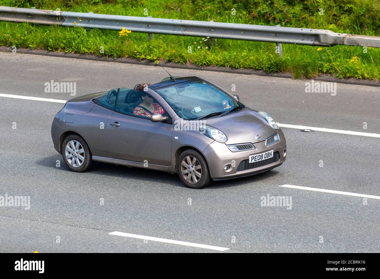 2008 beige Nissan Micra Acenta CC A; veicoli in movimento a traffico veicolare, automobili che guidano veicoli su strade del Regno Unito, motori, motori sulla rete autostradale M6. Foto Stock