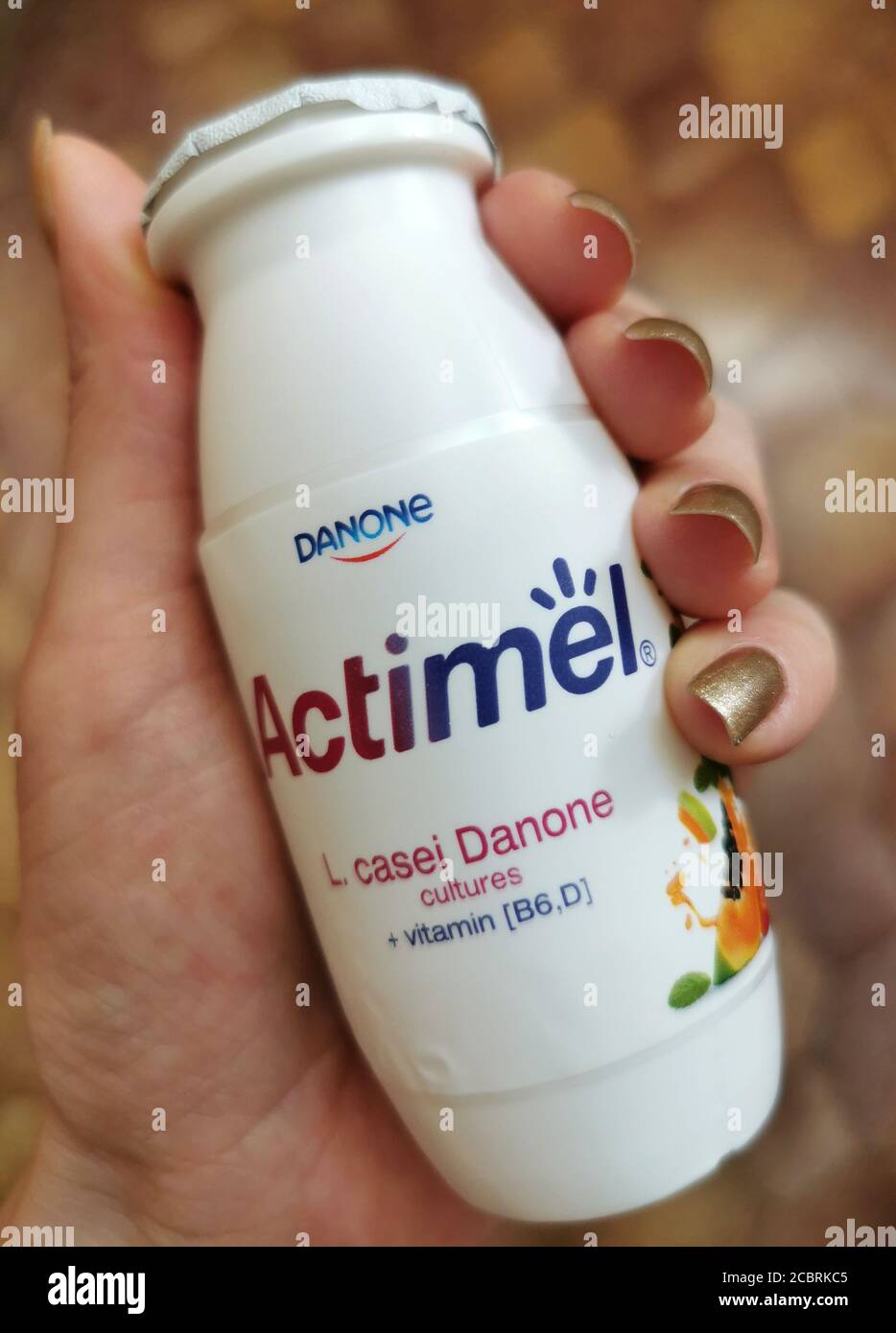 Bevanda di yogurt Actimel in mano. Cibo sano per i vostri batteri Foto Stock