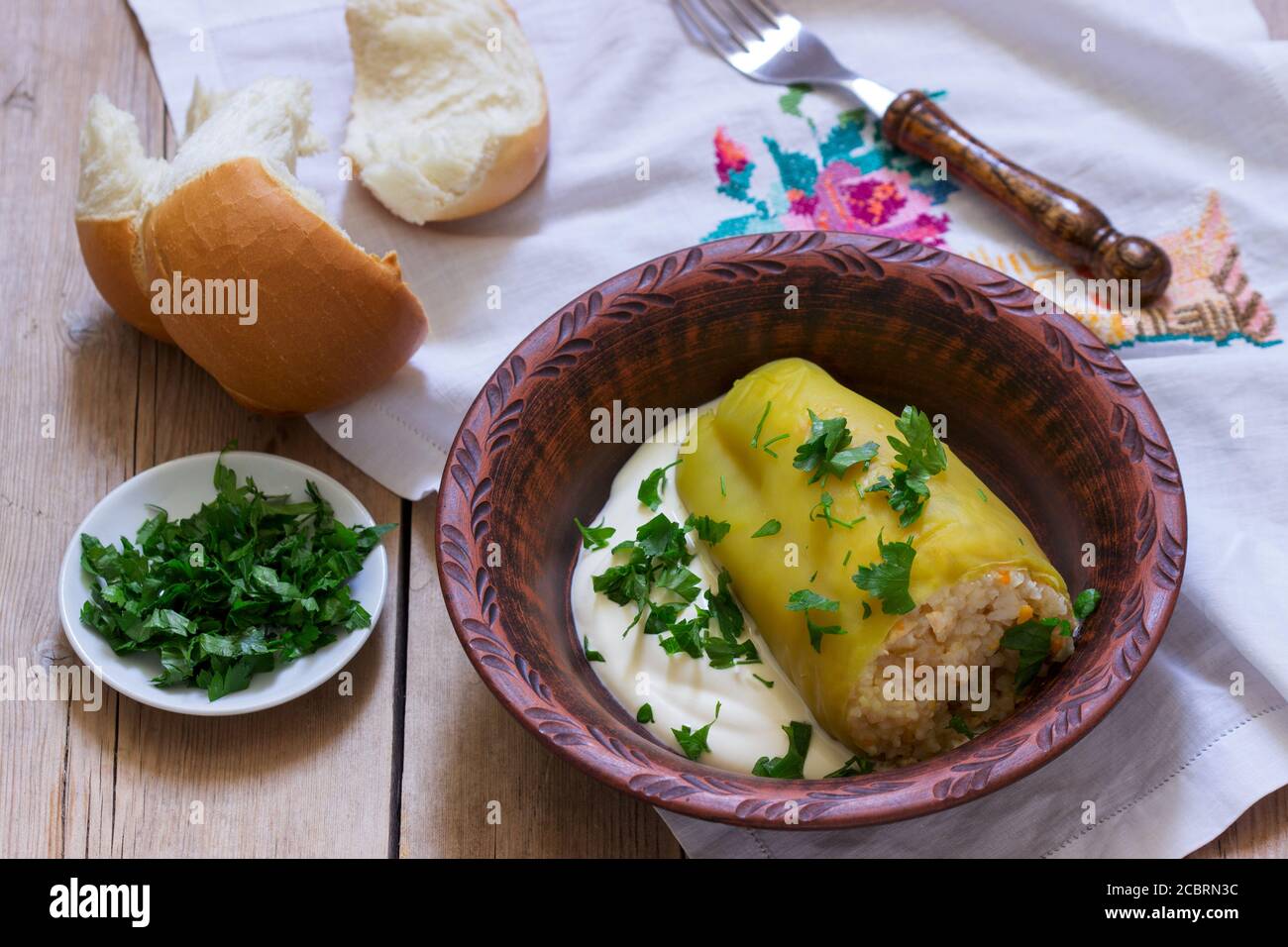 Peperoni ripieni serviti con panna acida e pane, un piatto tradizionale di diverse nazioni. Foto Stock