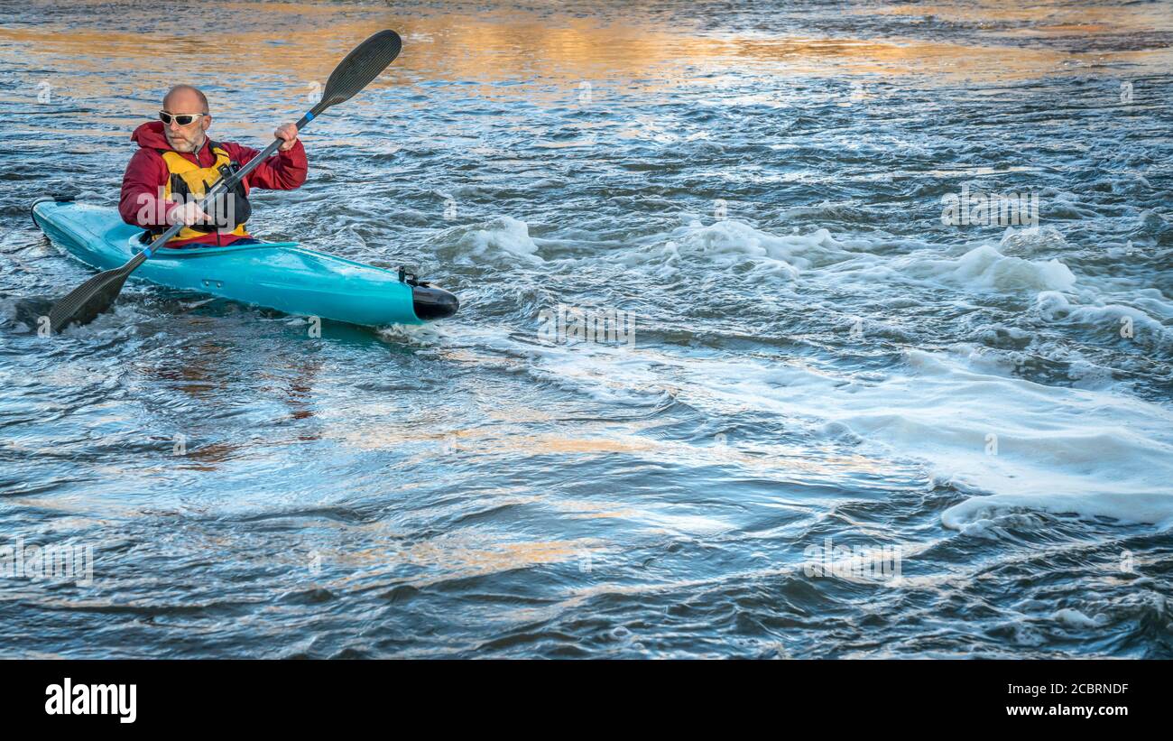 senior maschio che paddling un kayak whitewater su un fiume turbolento - South Platte River nel nord del Colorado Foto Stock
