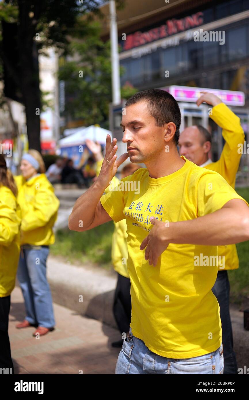 Seguaci del movimento religioso Falun dafa che fa ginnastica respiratoria Chi Kung in strada. 1° giugno 2012. Kiev, Ucraina Foto Stock