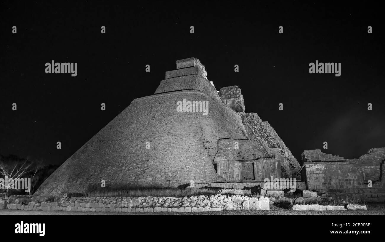 Un'immagine in bianco e nero della Piramide del Magico o Piramide del Nano illuminata di notte nelle rovine maya pre-ispaniche di Uxmal, Messico. Foto Stock