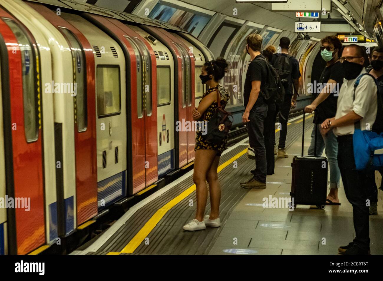 Piattaforma metropolitana di Londra di persone che indossano maschere facciali Foto Stock