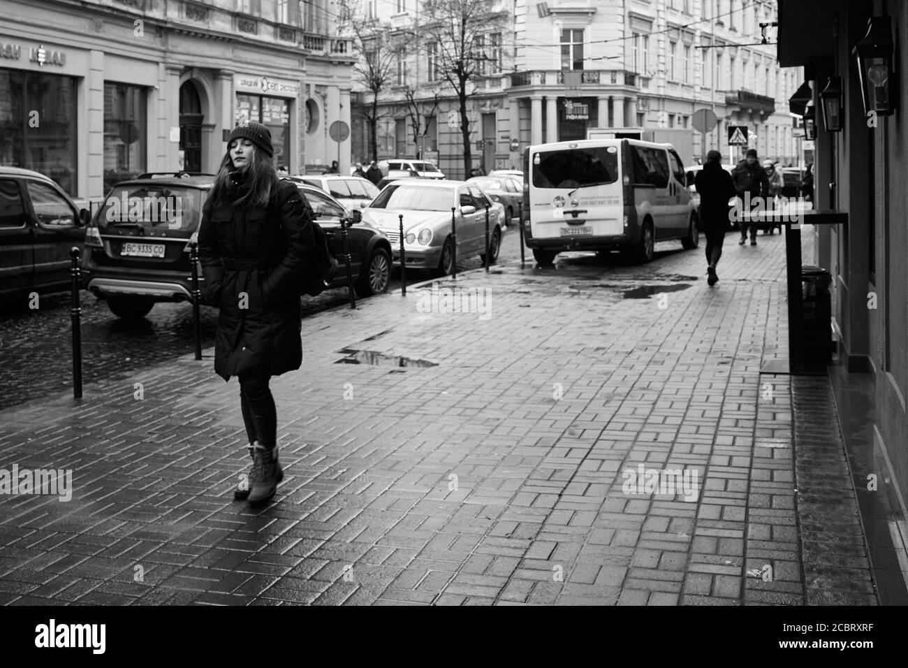 Sognare la ragazza. Lviv/Ucraina - 30 gennaio 2020: Sola ragazza sognante che cammina sulla via Akademika Hnatyuka Foto Stock