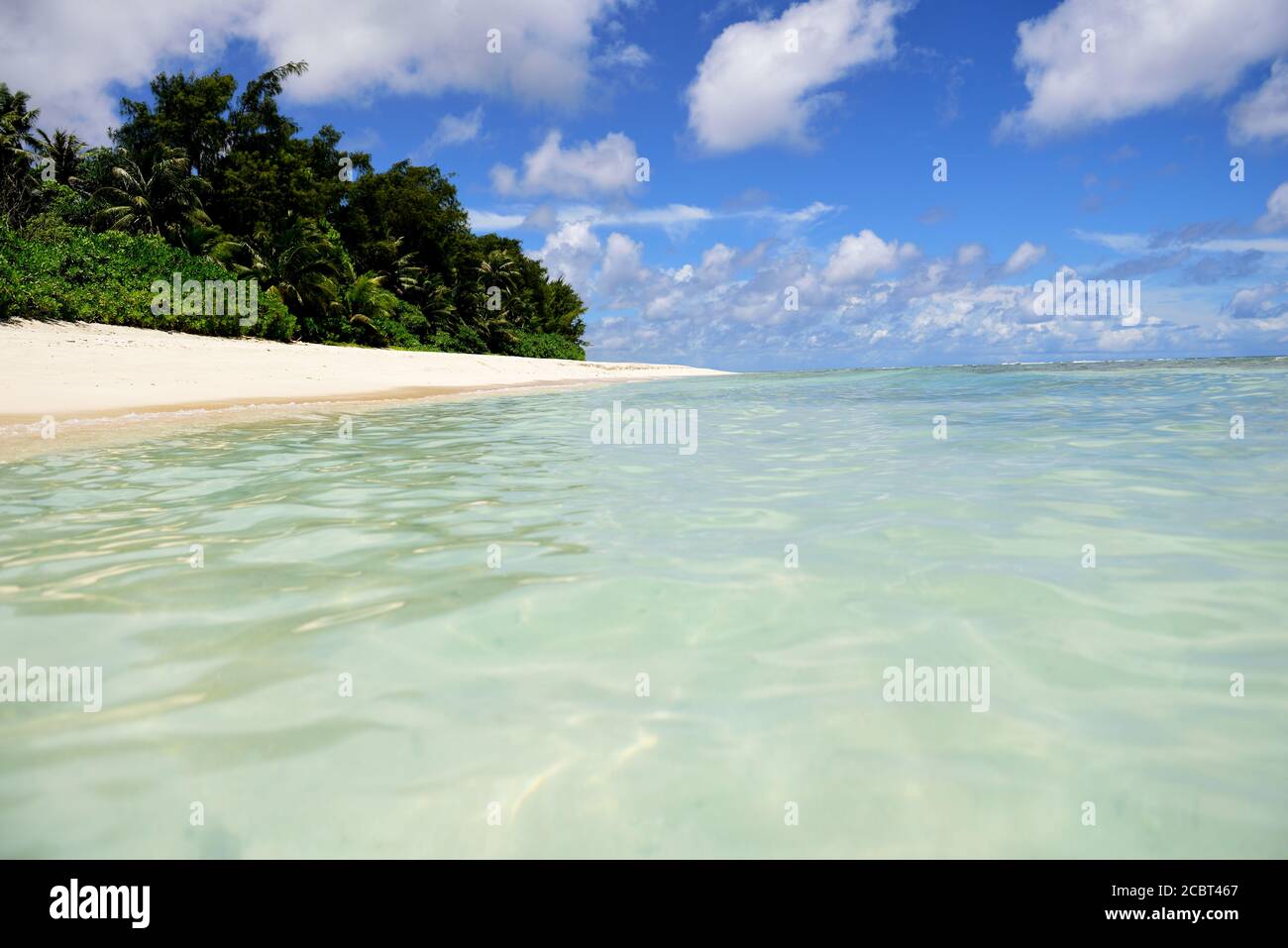 Spiaggia sabbiosa tropicale deserta con palme da cocco e acque blu chiare a Guam, Micronesia Foto Stock