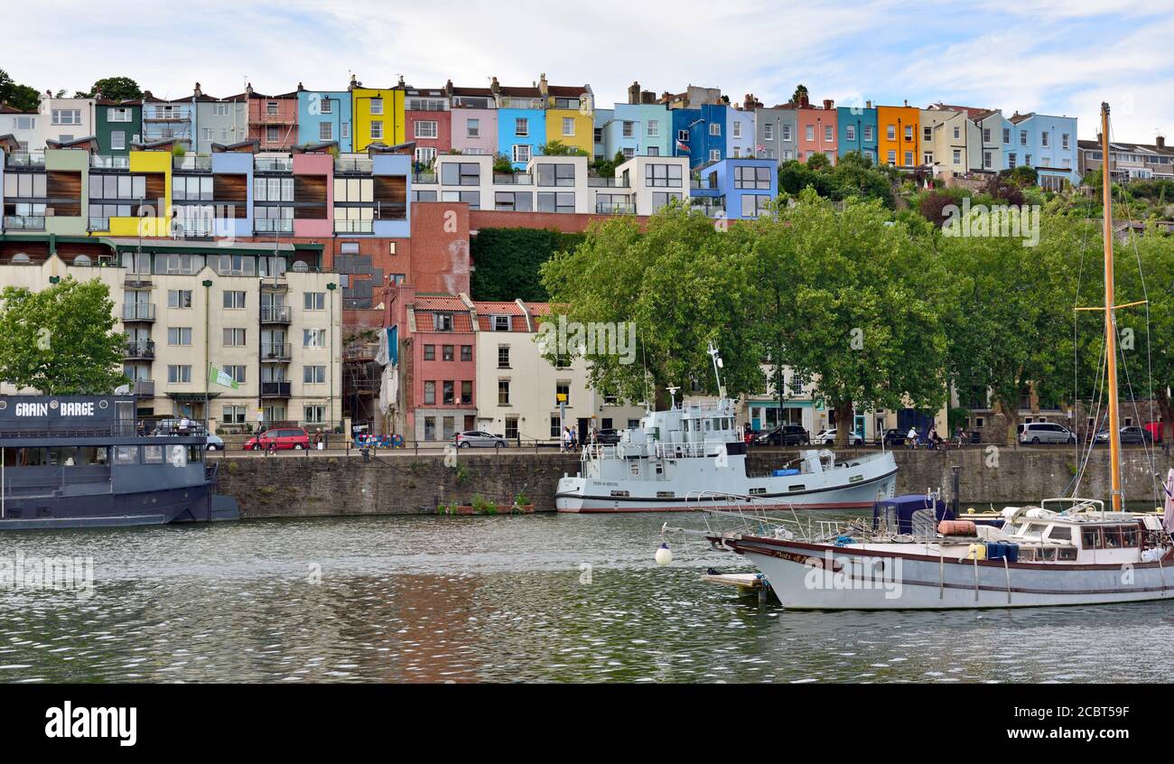 Barche sul porto galleggiante di Bristol con case colorate sulle colline Di Clifton Wood con vista sui moli Foto Stock