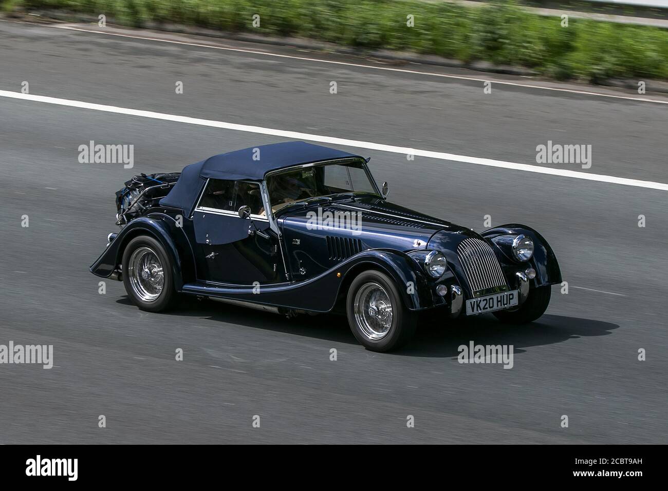 2020 Blue Morgan Plus Four con il nuovo motore BMW turbocompresso da 2.0 litri a quattro cilindri, che guida sull'autostrada M6 vicino a Preston a Lancashire, U. Foto Stock