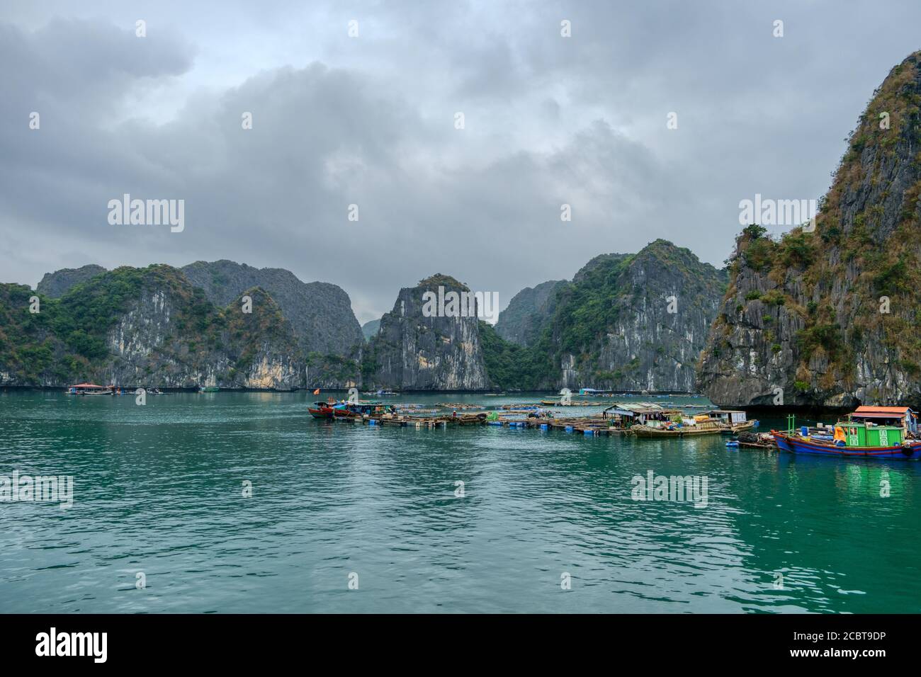 Ha Long Bay Vietnam, villaggio dei pescatori. Cielo nuvoloso, natura mozzafiato, case su Water.People vivono su barche e piattaforme d'acqua la maggior parte dei fis Foto Stock